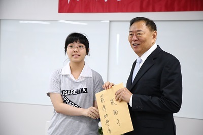The award-winning student giving a thank-you note to the EMBA11 alumni representativeImage
