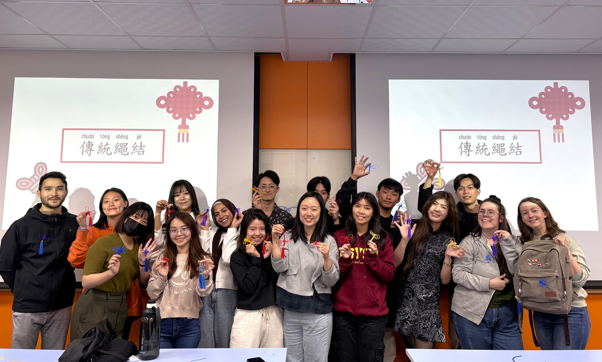 同學們展示著親手製作的中國結作品圖片