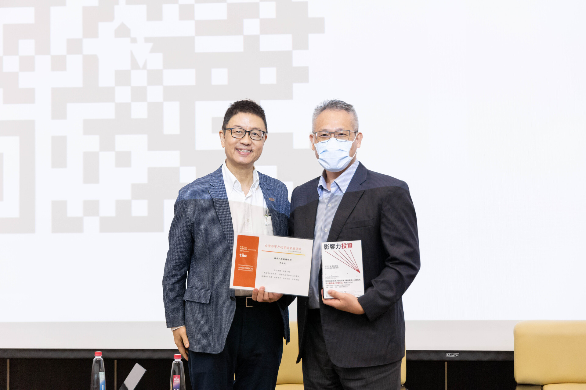 CEO of Taiwan Impact Investing Association Tao-kuei Wu awards a certificate of appreciation and presents a book to Vice President of Cathay Life Wen-Jui Li