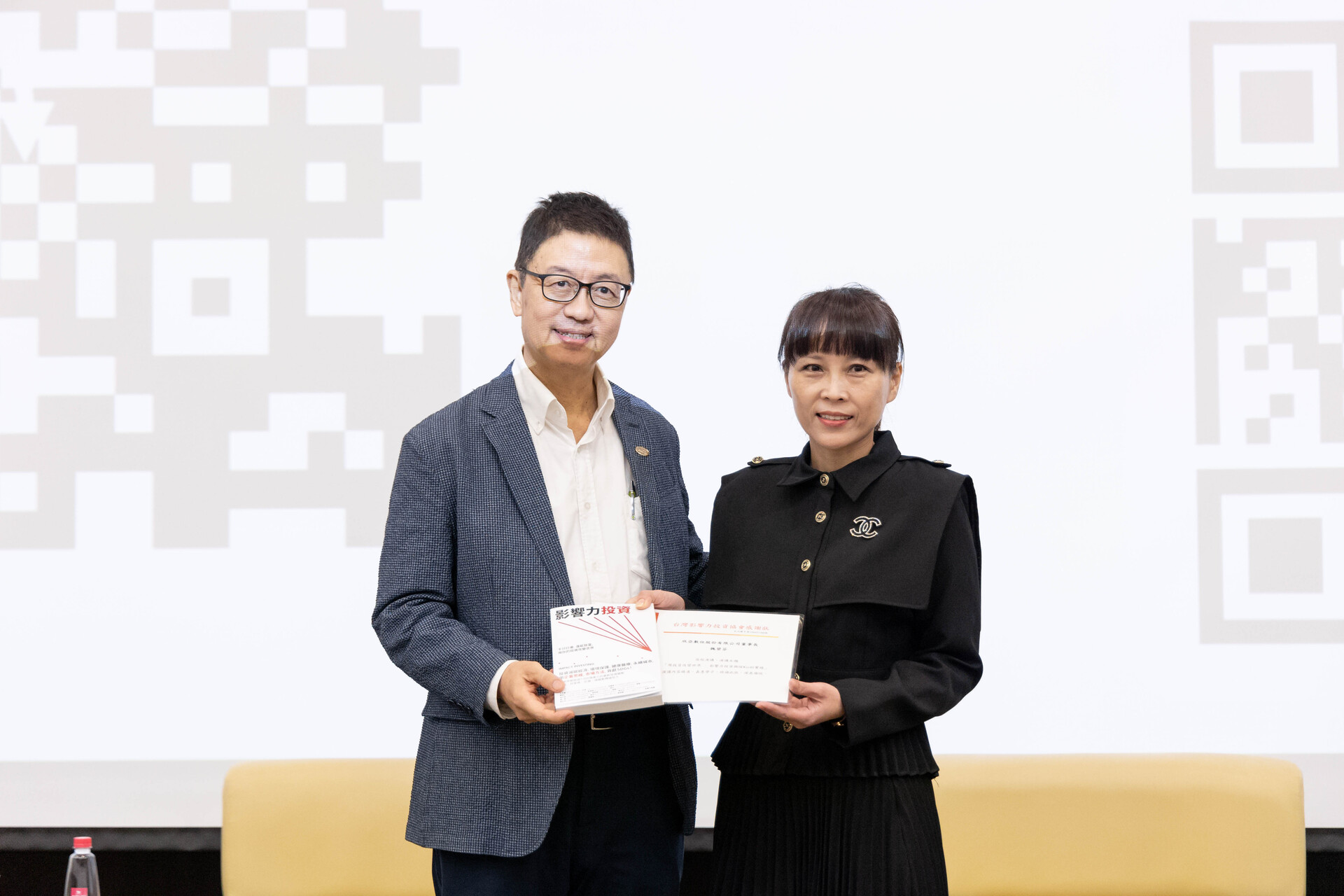 CEO of Taiwan Impact Investing Association Tao-kuei Wu awards a certificate of appreciation and presents a book to Chairman of Sinya Digital Co. Pi-fen Wei
