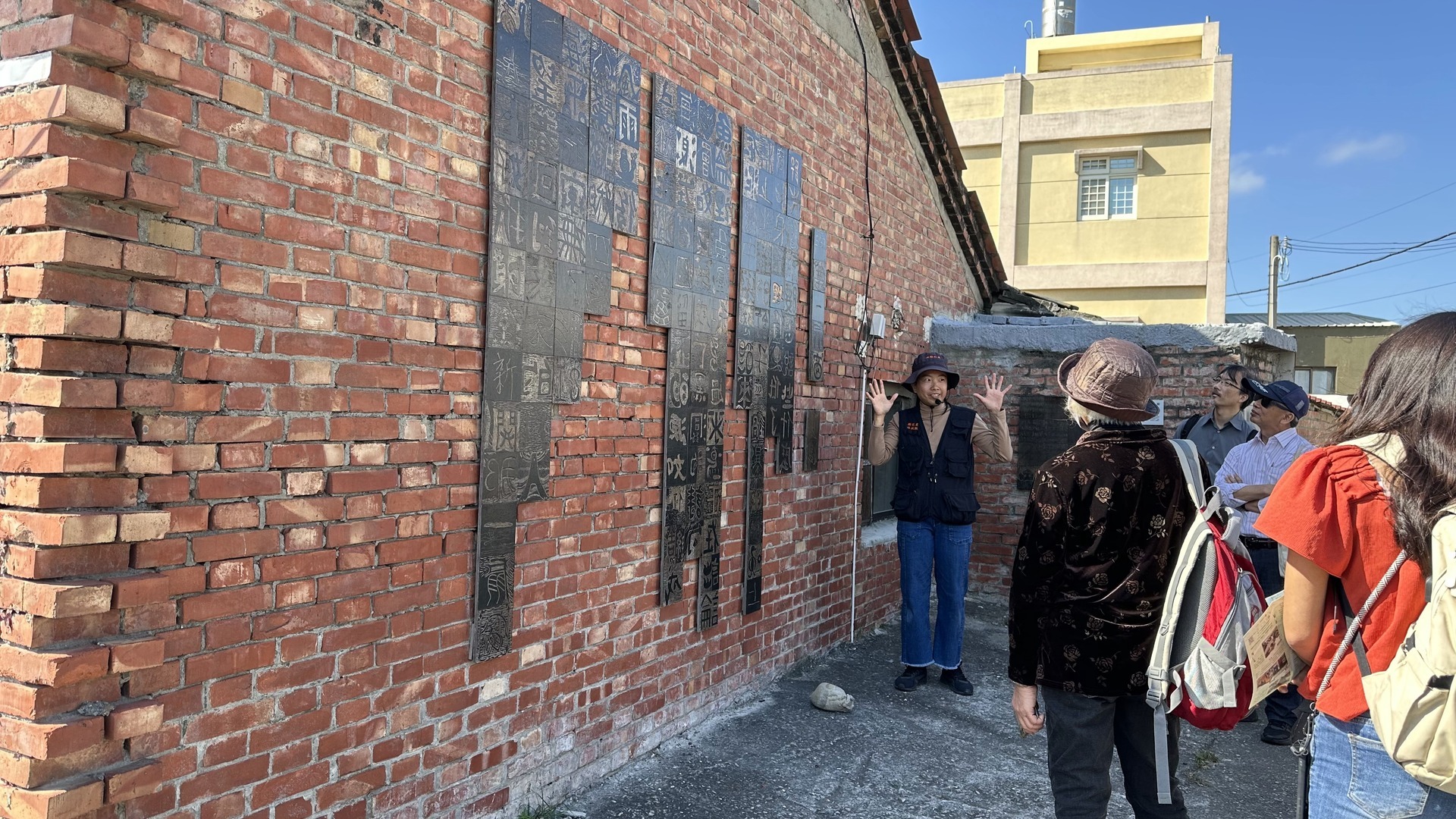 Tour guide Lin Pei-Jen providing an explanation of the Chenglong community's art projects