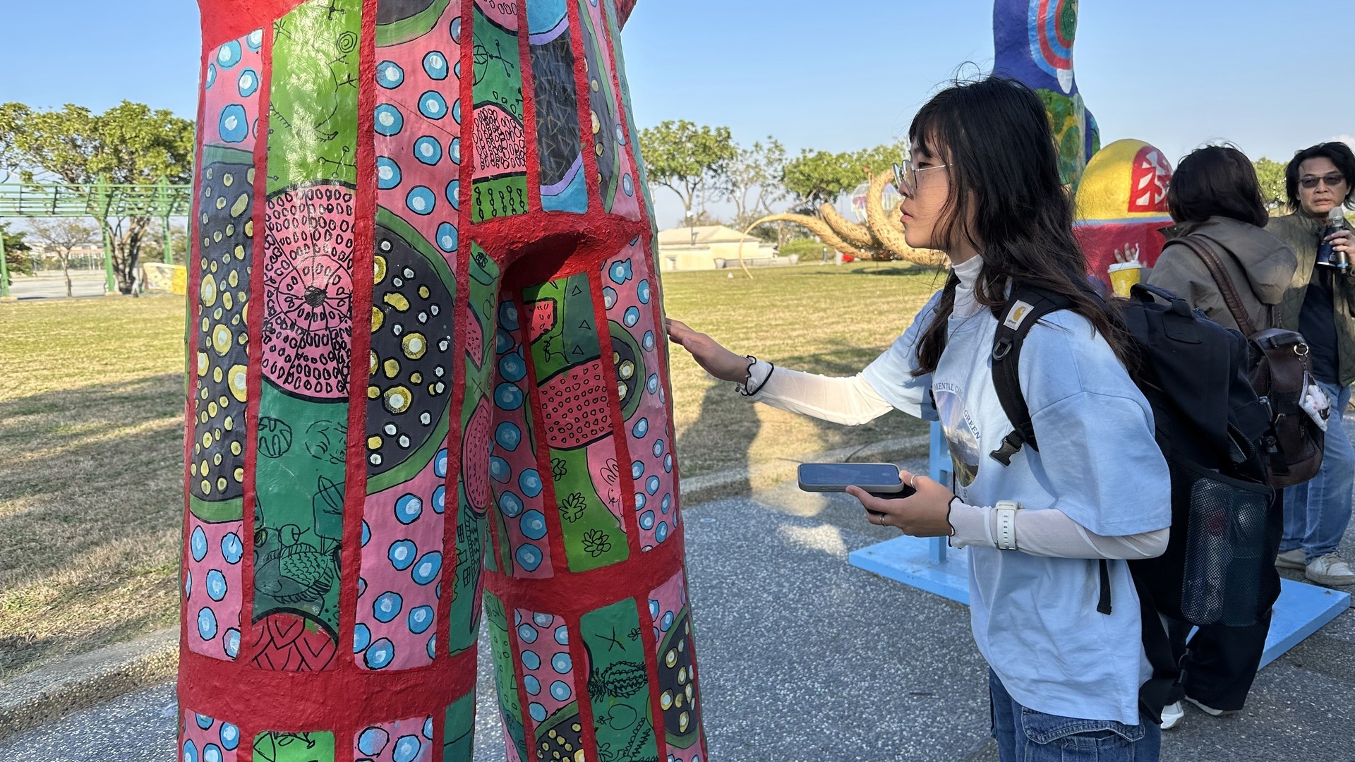 Business management students appreciating the "Fu, Lu, Shou" art installation