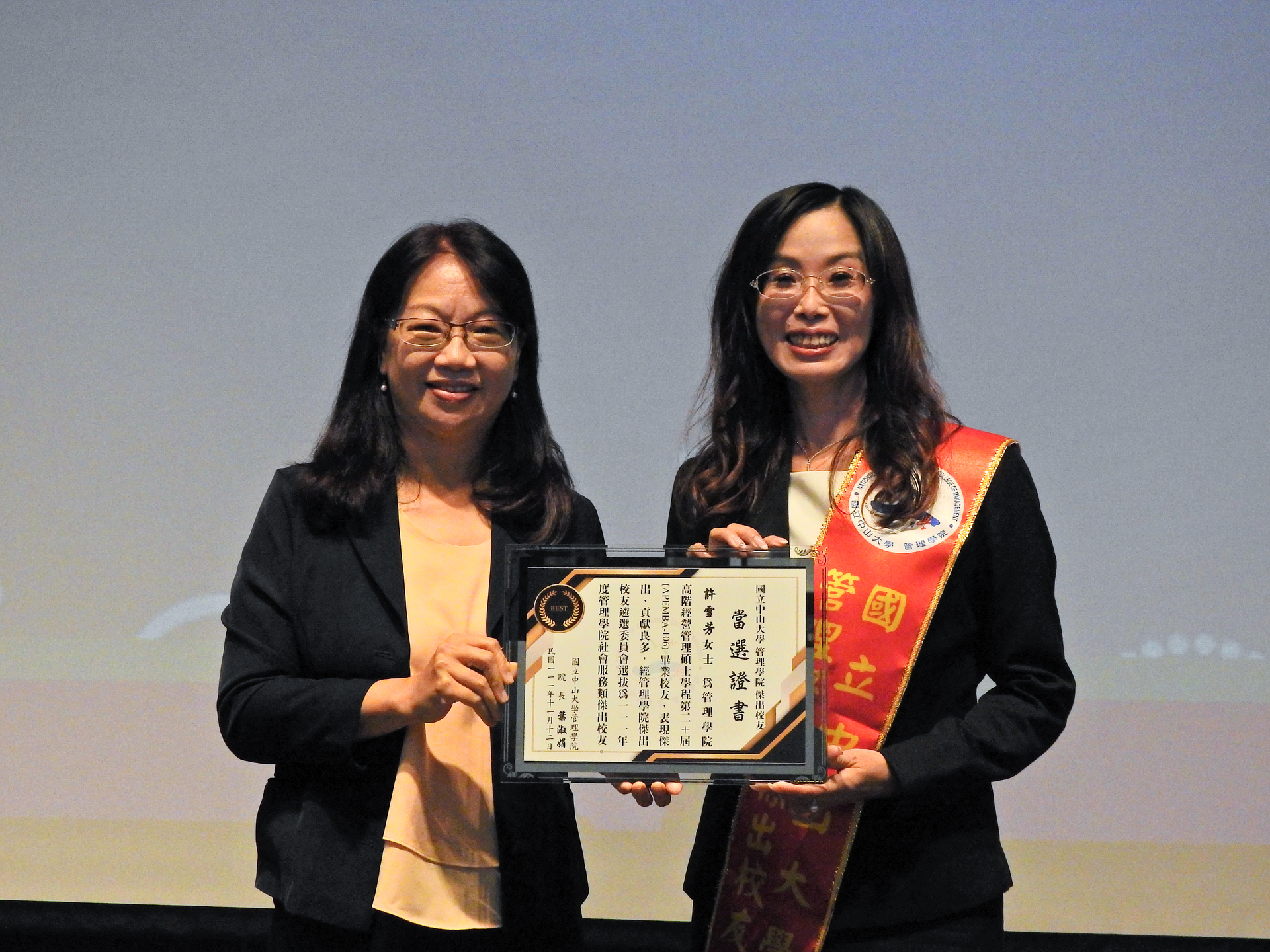 College of Management Dean Shu-chuan Jennifer Yeh (left) presents the 2022 Outstanding Alumni Award to Hsueh-fang Hsu (right)