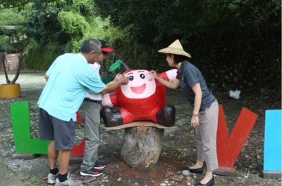 南勝社區發展協會與中山大學代表，為紙漿公仔進行畫龍點睛儀式。圖／中山大學提供圖片