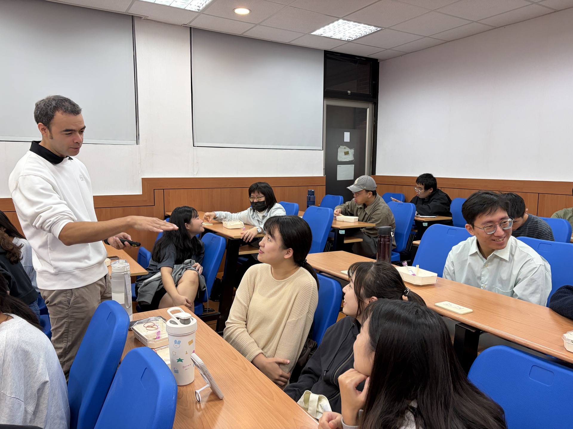 The speaker interacts with students during group discussions and offers guidance.Image