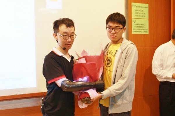 中山大學助理教授王致遠（左）四肢截肢，裝上電子手臂及義肢後回校教書，今年3月接受雙臂移植手術成功，目前復健中。（取自中山大學管理學院）圖片