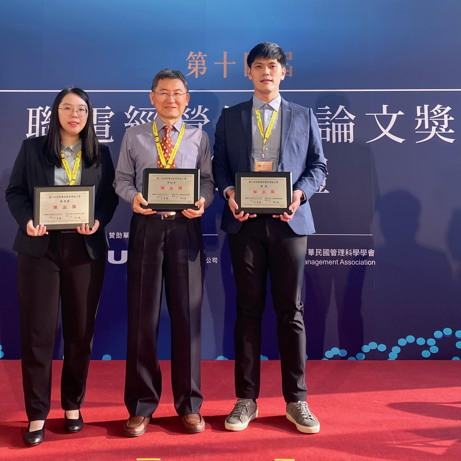聯電經營管理論文傑出獎獲獎同學資管系鄭鈞（右）、陳怡蓁（左），與指導教授之一邱兆民特聘教授合影圖片