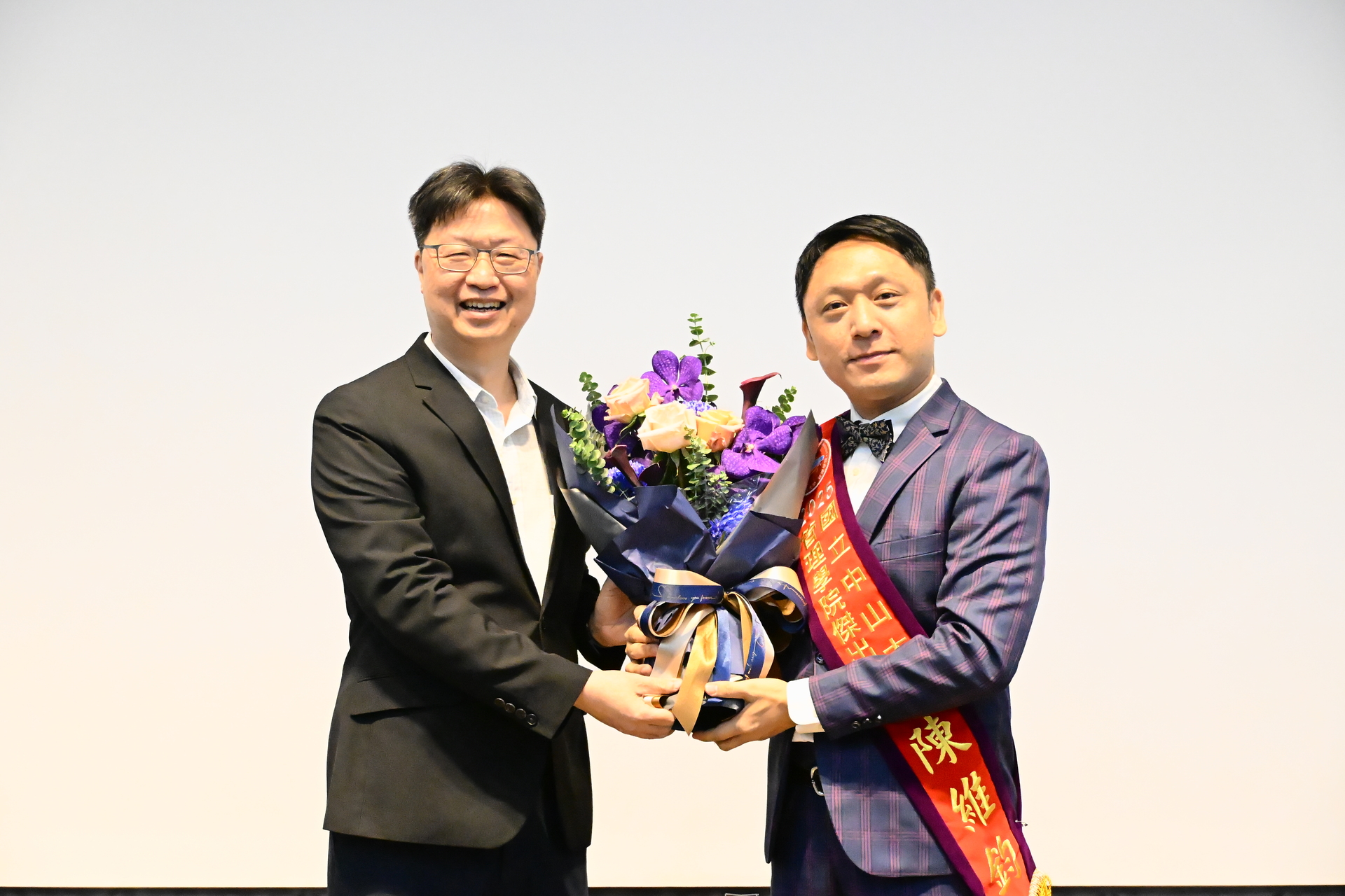 鄭安授教授代表行傳所獻花祝賀予行傳所傑出校友陳維鈞總經理圖片