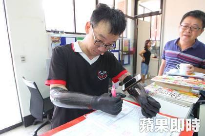 王致遠用電子手臂在文件上簽名。楊適吾攝圖片